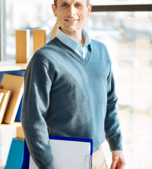 professional-therapist-handsome-positive-nice-man-smiling-and-looking-at-you-while-holding-his-notes